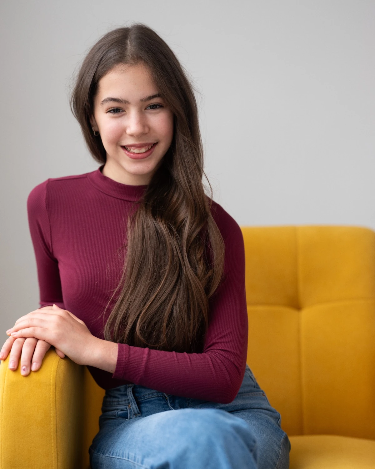 Samara seated on a yellow sofa